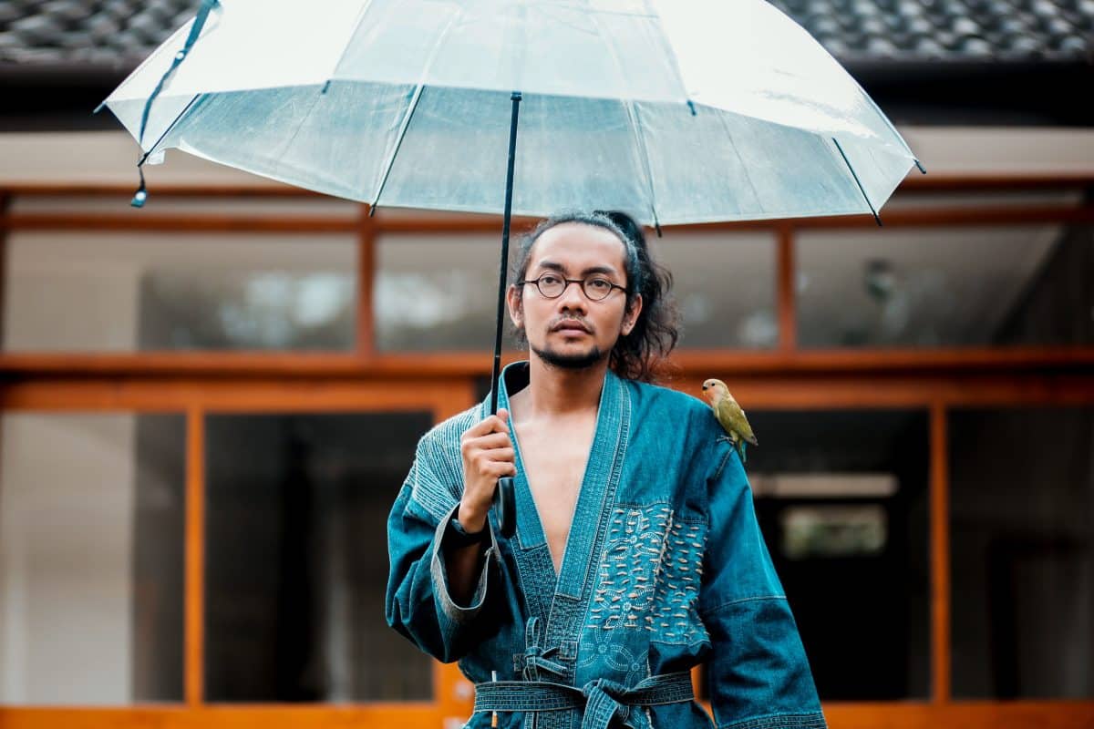 Homme en kimono avec un parapluie