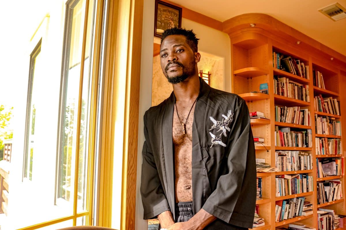 Homme en kimono devant une bibliothèque