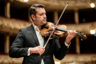 Portrait de Renaud Capuçon violoniste jouant sur scène dans une salle de concert prestigieuse, tenue de concert noire et expression musicale intense